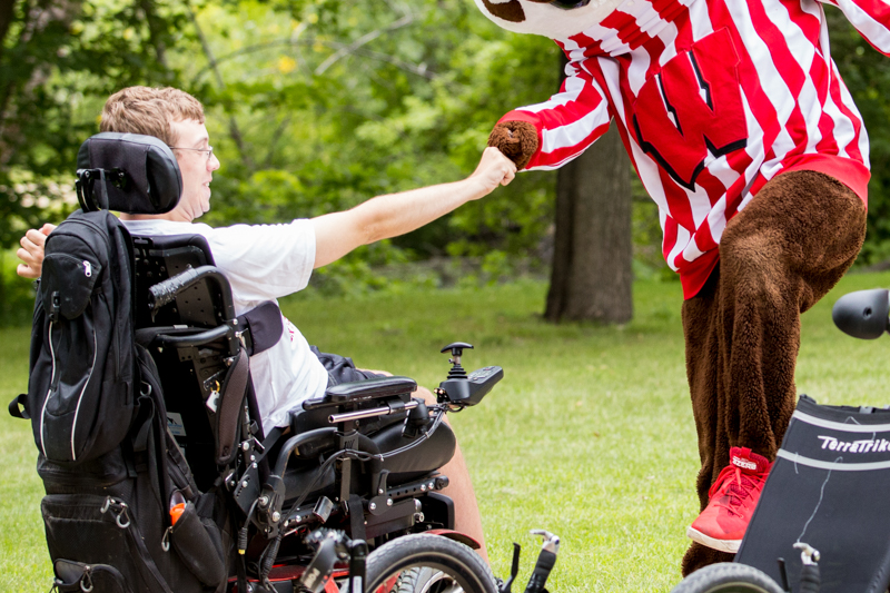 Bucky badger fist bumping a student in a wheelchair