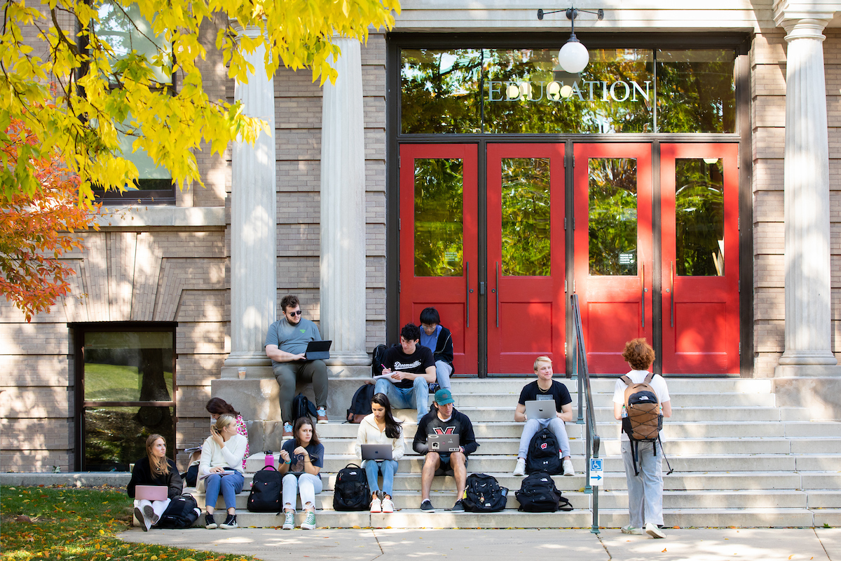 Group of students studying outside of education building